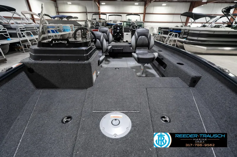 Slide: The Image of 2026 Lund 1775 Adventure SS boat interior with seating and console, displayed in a showroom. - 14