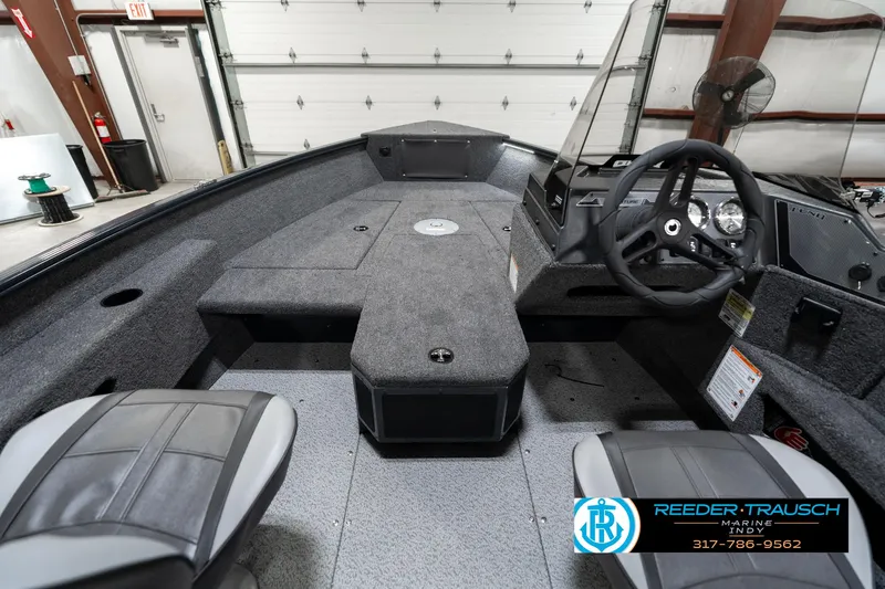 Slide: The Image of 2026 Lund 1775 Adventure SS boat interior with steering wheel and seating in a showroom. - 18