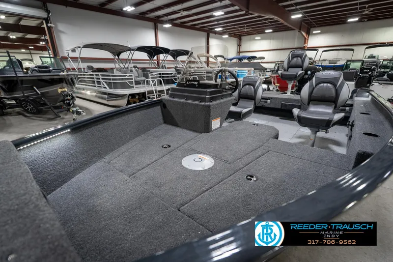 Slide: The Image of 2026 Lund 1775 Adventure SS boat interior in showroom, featuring seating and storage. - 21