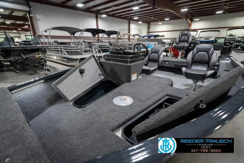 Slide: The Image of 2026 Lund 1775 Adventure SS boat interior with seating and storage, displayed in a showroom. - 22