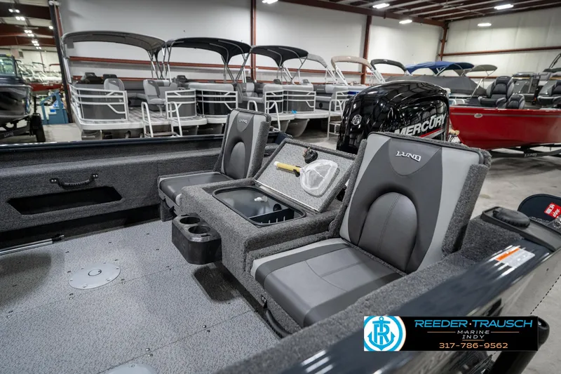 Slide: The Image of 2026 Lund 1775 Adventure SS boat interior with seating and Mercury engine in showroom. - 28
