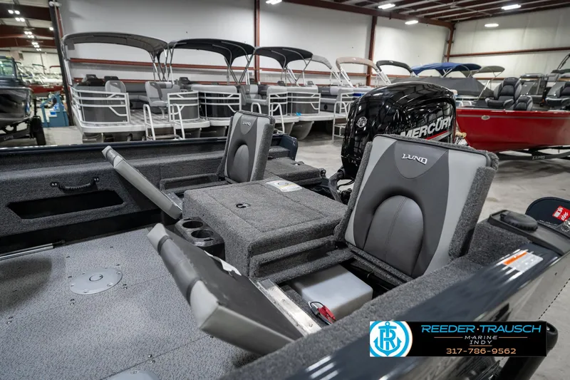 Slide: The Image of 2026 Lund 1775 Adventure SS boat interior with seating and Mercury engine in showroom. - 29