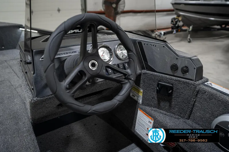 Slide: The Image of 2026 Lund 1775 Adventure SS boat dashboard with steering wheel and gauges. - 31