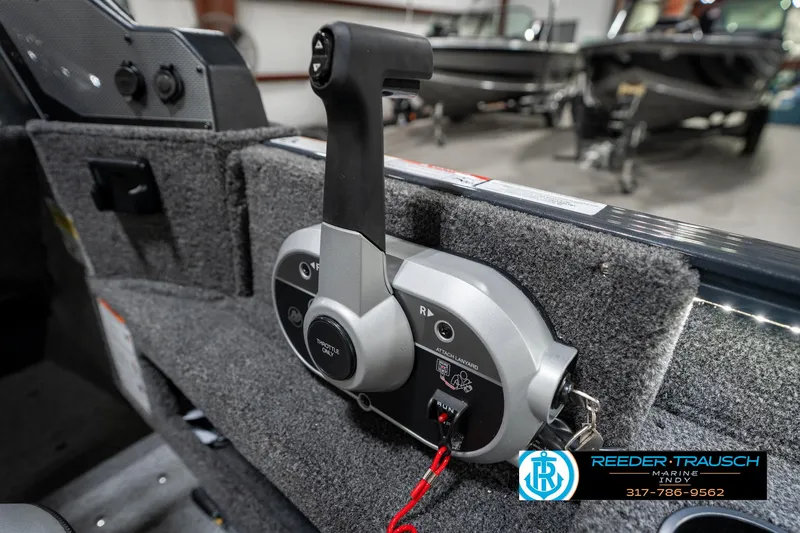 Slide: The Image of 2026 Lund 1775 Adventure SS boat throttle control in showroom setting. - 35