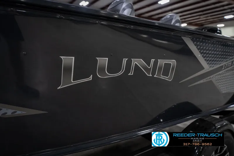 Slide: The Image of 2026 Lund 1775 Adventure SS boat side view with logo, displayed indoors. - 48