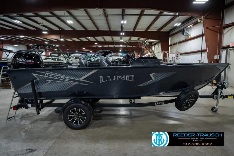 Slide: The Image of 2026 Lund 1775 Adventure SS boat in showroom, featuring sleek design and Mercury engine. - 5