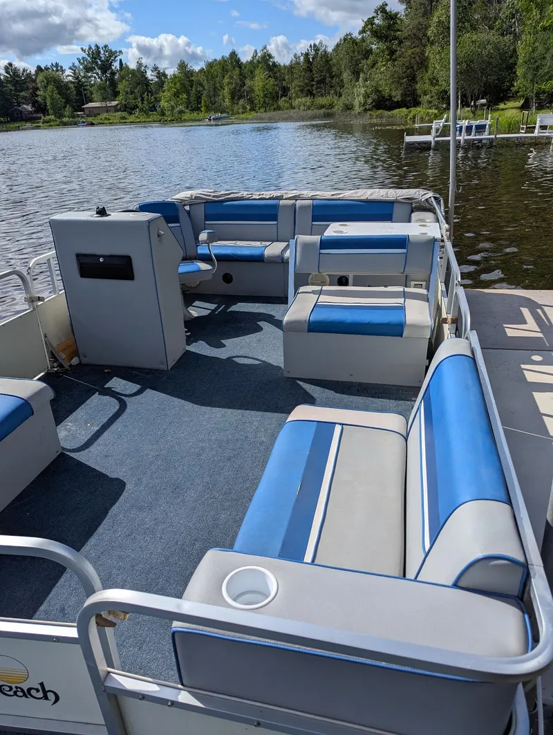 Slide: The Image of Pontoon boat on a lake, Palm Beach Super 220, 1991 model, with blue and white seating. - 11