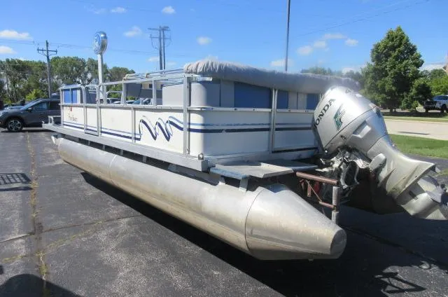 Slide: The Image of 1991 Palm Beach Super 220 pontoon boat with Honda outboard motor, parked on pavement. - 17