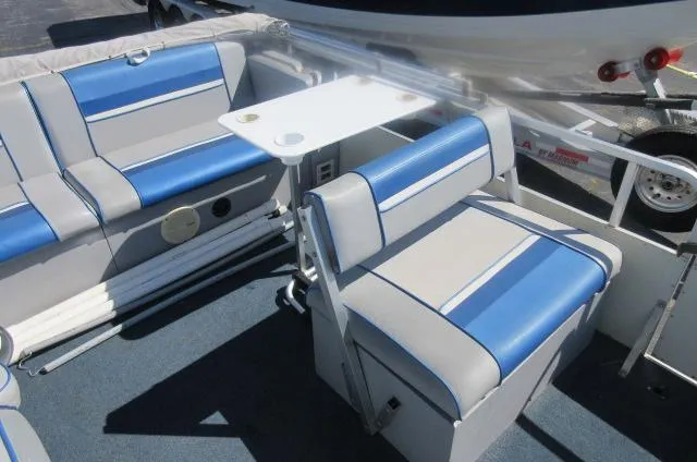 Slide: The Image of 1991 Palm Beach Super 220 boat interior with blue and gray seating and a small table. - 19
