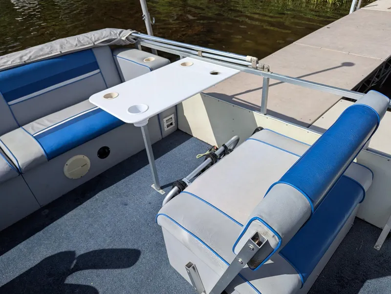 Slide: The Image of Interior of 1991 Palm Beach Super 220 boat with blue and white seating and table. - 9