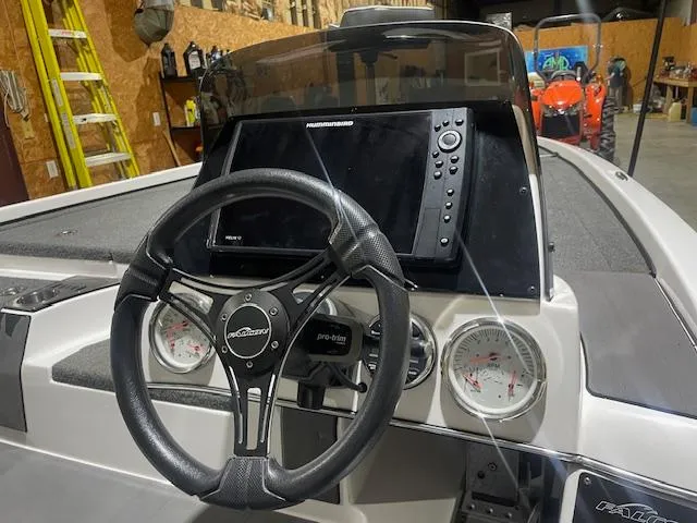 Slide: The Image of 2023 Falcon Boats F205 dashboard with steering wheel and navigation system in a garage setting. - 8