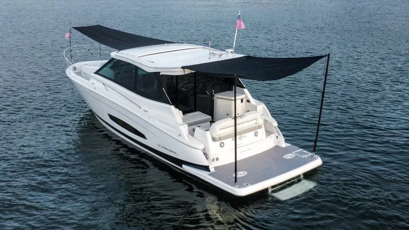 Slide: The Image of 2021 Regal 36 Grande Coupe yacht on water, featuring sleek design and sunshade canopy. - 13