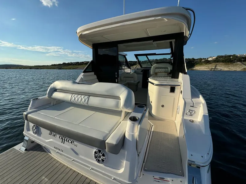 Slide: The Image of 2021 Regal 36 Grande Coupe yacht on serene water, featuring luxurious seating and modern design. - 14