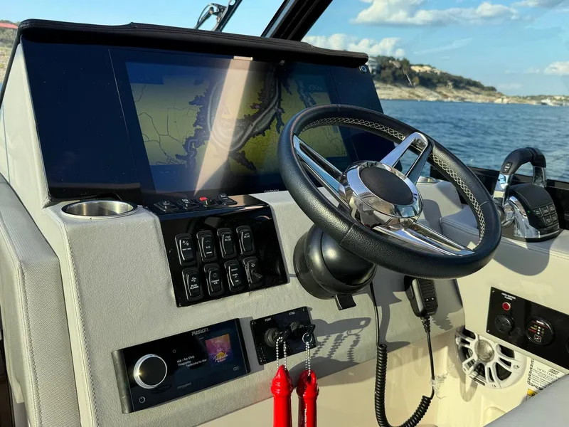 Slide: The Image of Control panel of 2021 Regal 36 Grande Coupe boat with steering wheel and navigation display. - 31