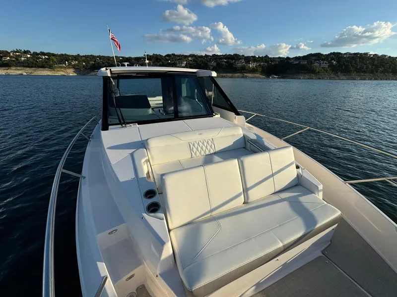 Slide: The Image of 2021 Regal 36 Grande Coupe yacht on serene water with luxurious seating. - 38