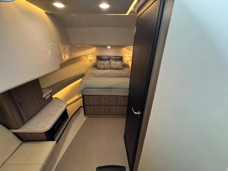 Slide: The Image of 2021 Regal 36 Grande Coupe cabin interior with bed, modern lighting, and wood accents. - 45