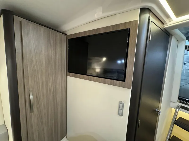 Slide: The Image of 2021 Regal 36 Grande Coupe interior with mounted TV and wooden cabinetry. - 49