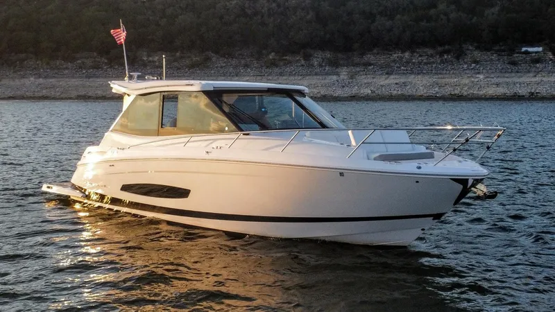 Slide: The Image of 2021 Regal 36 Grande Coupe boat on water at sunset. - 6