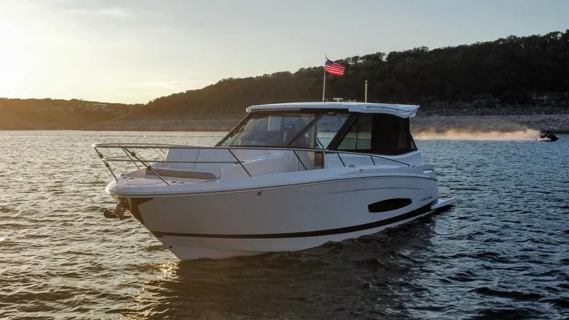 Slide: The Image of 2021 Regal 36 Grande Coupe boat on a serene lake at sunset. - 8
