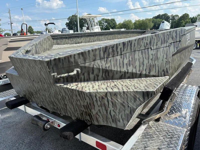 Slide: The Image of 2025 Edge Duck Boats Standard 656DB with camouflage design on a trailer. - 2
