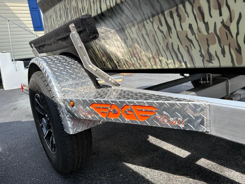 Slide: The Image of 2025 Edge Duck Boats Standard 656DB trailer with camouflage design and diamond plate fender. - 7