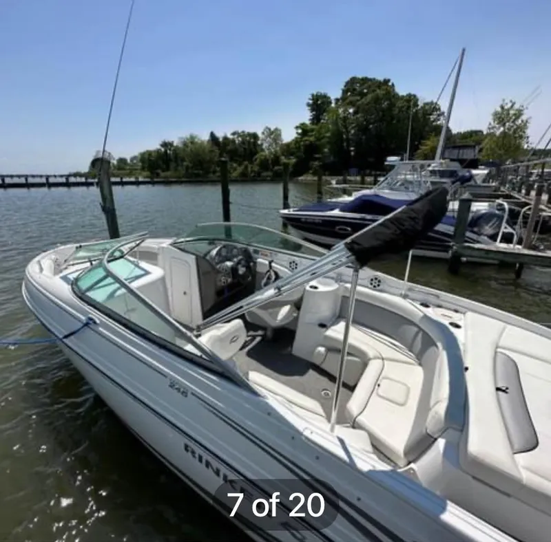 Slide: The Image of 2015 Rinker 246 Captiva Bowrider docked at marina, sunny day, calm water. - 4
