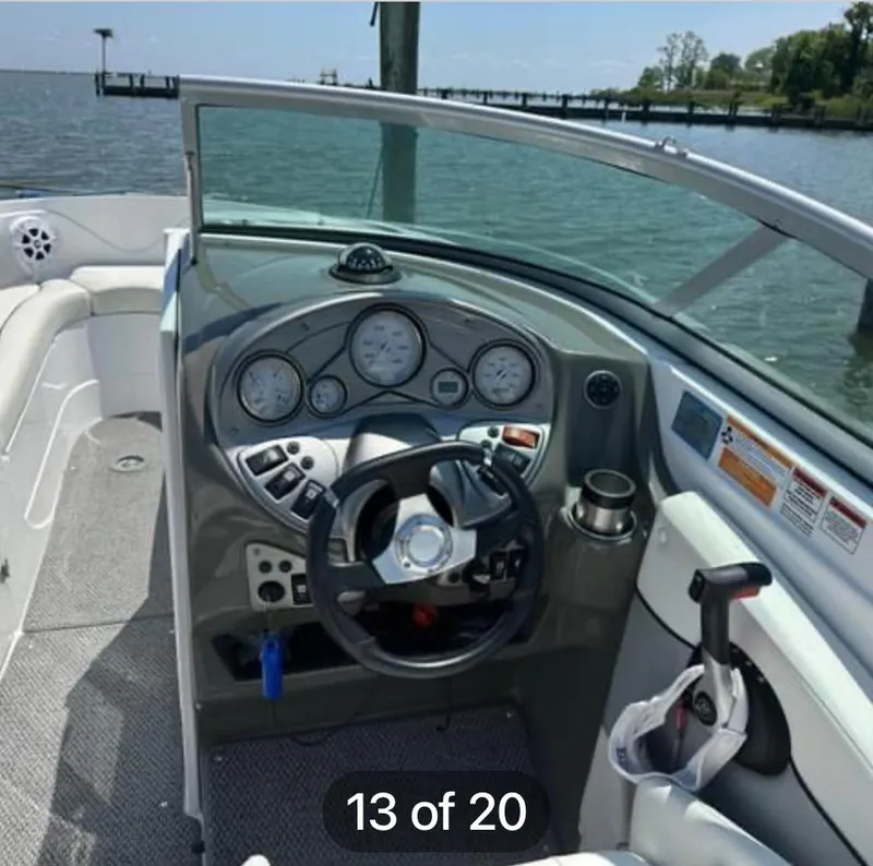 Slide: The Image of 2015 Rinker 246 Captiva Bowrider dashboard with steering wheel and gauges, docked by the water. - 7