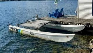 Slide: The Image of 2017 Hobie 16 catamaran docked by a lakeside with blue chairs. - 5