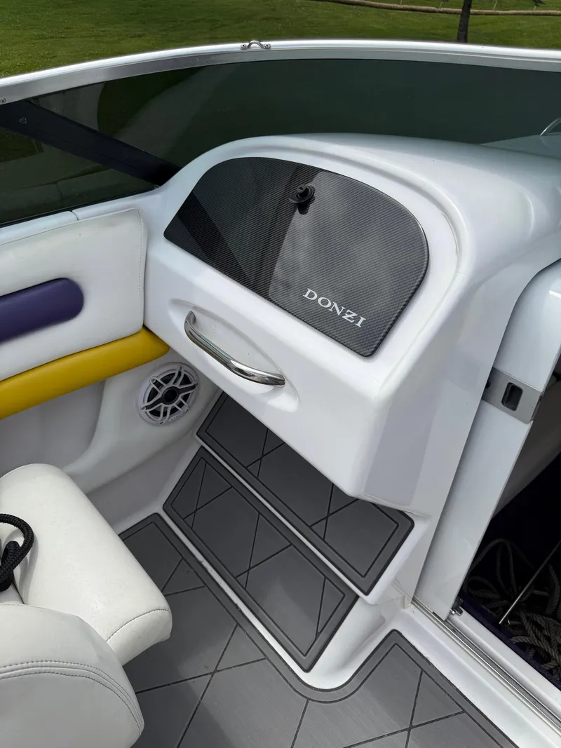 Slide: The Image of 1999 Donzi 26 ZX boat interior with white seating, yellow accents, and Donzi branding. - 17