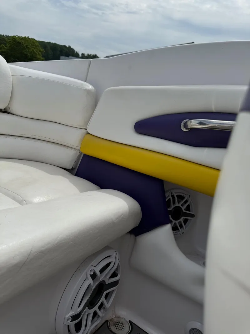 Slide: The Image of 1999 Donzi 26 ZX boat interior with white, yellow, and purple upholstery, featuring speaker detail. - 18