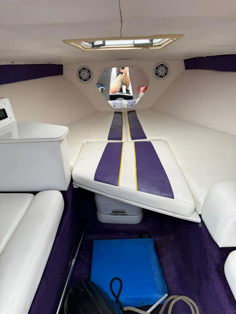 Slide: The Image of Interior of a 1999 Donzi 26 ZX boat with white and purple seating. - 19