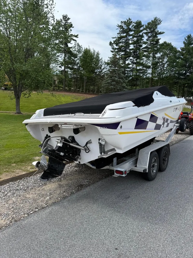 Slide: The Image of 1999 Donzi 26 ZX boat on trailer, parked on roadside with trees in background. - 3