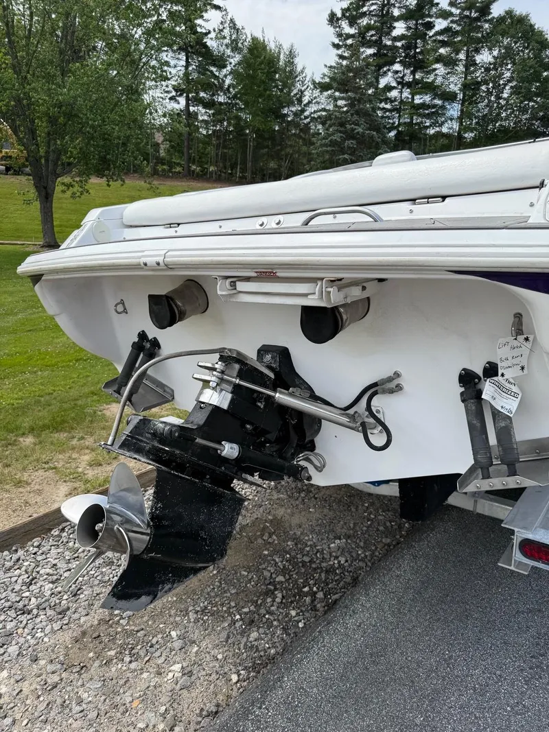 Slide: The Image of 1999 Donzi 26 ZX boat stern with outboard motor and propeller, parked on gravel. - 5