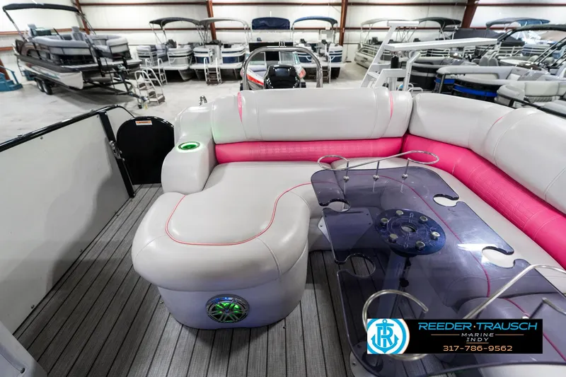 Slide: The Image of 2019 Avalon Ambassador 27' pontoon boat interior with pink and gray seating, glass table, and speaker. - 18