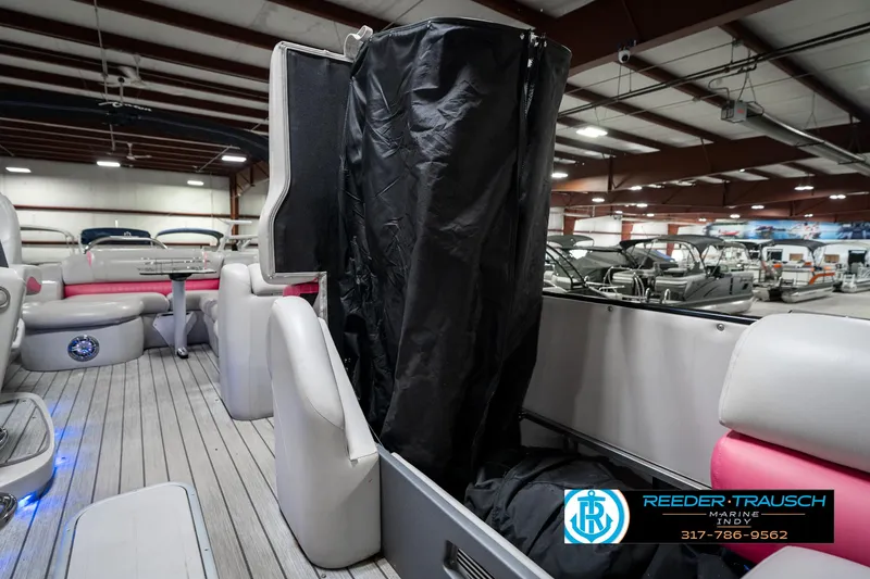 Slide: The Image of 2019 Avalon Ambassador 27' pontoon boat interior with seating and storage, displayed indoors. - 27