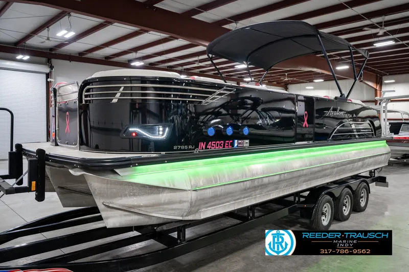 Slide: The Image of 2019 Avalon Ambassador 27' pontoon boat with green LED lights in a showroom. - 3