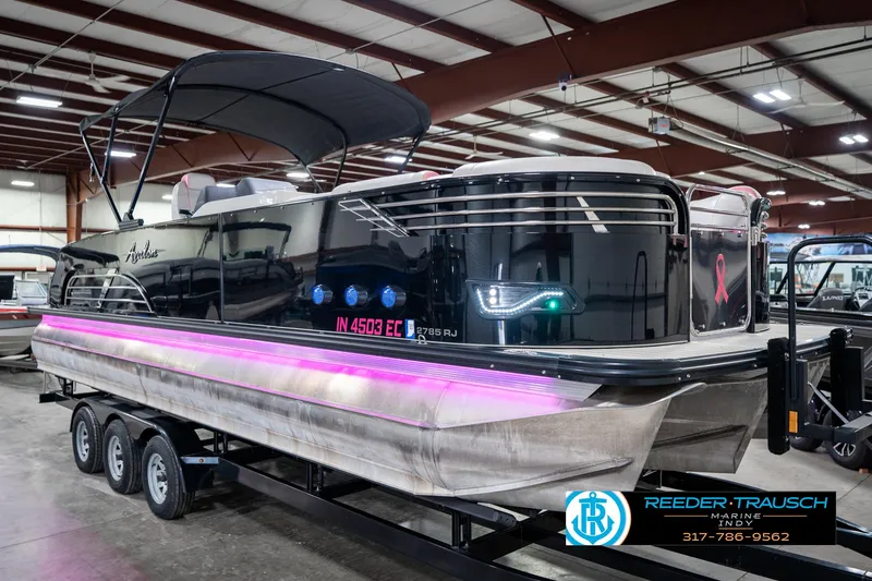 Slide: The Image of 2019 Avalon Ambassador 27' pontoon boat with pink LED lights in a showroom. - 6