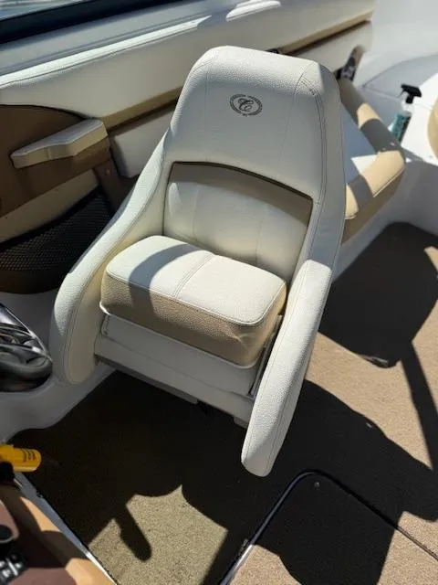 Slide: The Image of 2020 Cobalt CS23 boat interior with beige captain's chair and brown accents. - 10