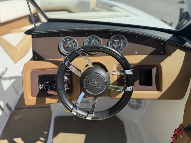 Slide: The Image of Steering wheel and dashboard of 2020 Cobalt CS23 boat, featuring gauges and controls. - 12
