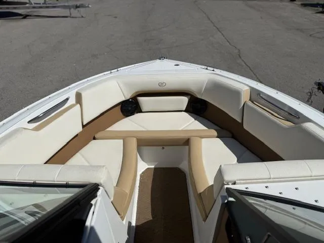 Slide: The Image of 2020 Cobalt CS23 boat interior with beige and white seating, docked on pavement. - 4