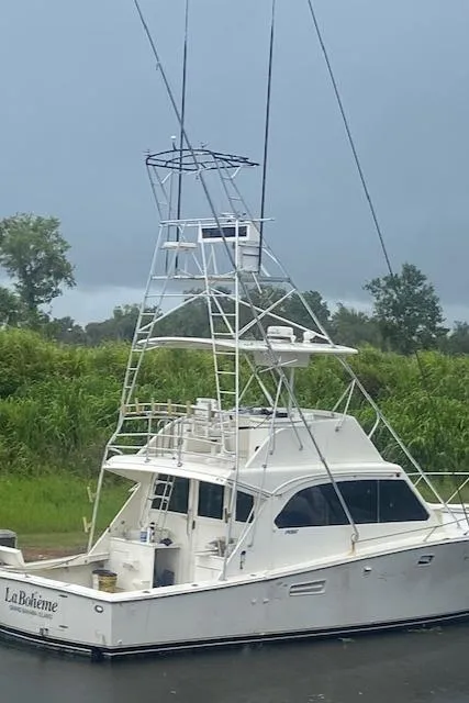 The Image of 1984 Post 43 Sport Fisherman boat docked, featuring tall tower and sleek design. - 1