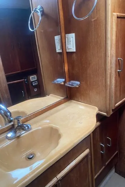 Slide: The Image of 1984 Post 43 Sport Fisherman bathroom with wooden cabinets and beige sink. - 13