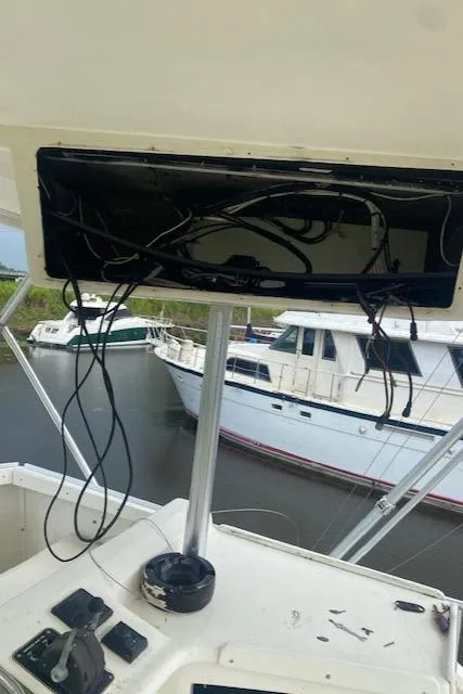 Slide: The Image of 1984 Post 43 Sport Fisherman boat with exposed wiring and control panel, docked near other boats. - 20