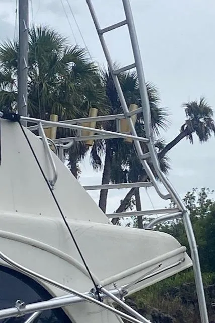 Slide: The Image of 1984 Post 43 Sport Fisherman boat with metal ladder, palm trees in background. - 5