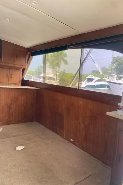 Slide: The Image of Interior of 1984 Post 43 Sport Fisherman boat with wood paneling and large windows. - 8