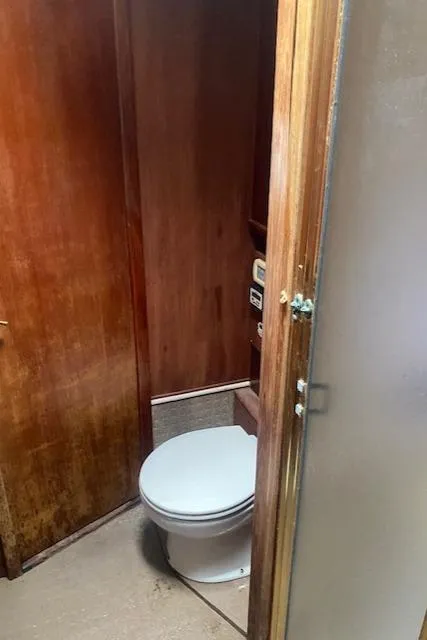 Slide: The Image of 1984 Post 43 Sport Fisherman boat bathroom with wooden interior and toilet. - 12