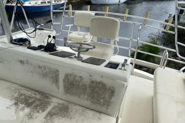 Slide: The Image of 1984 Post 43 Sport Fisherman boat interior with worn seating and control panel. - 19