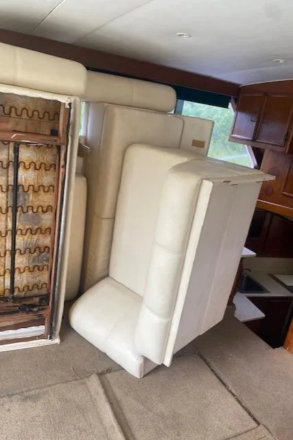 Slide: The Image of 1984 Post 43 Sport Fisherman interior with stacked white cushions and wooden cabinetry. - 9