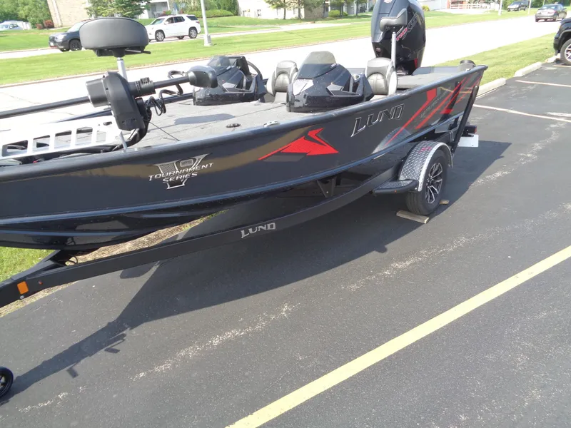 Slide: The Image of 2025 Lund 1875 Pro-V Bass XS boat on trailer, parked in a lot. - 2