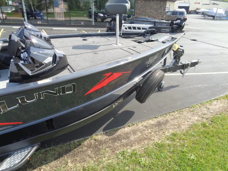 Slide: The Image of 2025 Lund 1875 Pro-V Bass XS boat on trailer, parked outdoors. - 6
